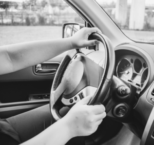 Photo of two hands on a steering wheel